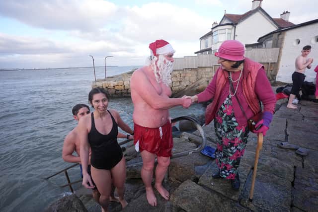 Thousands thronged to the Forty Foot promontory in Sandycove as people pulled on Santa hats to take part in the festive dip despite bitterly cold conditions.