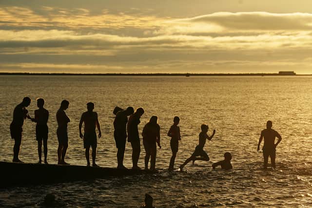 The colourful scene overhead was matched by families arriving in Christmas jumpers, swimming togs and outdoor changing robes.