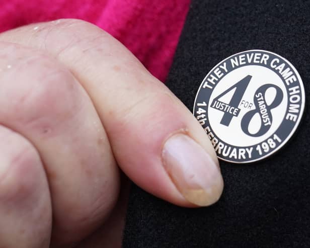 A family member touches her Stardust lapel pin on her way into Dublin Coroner’s Court (Brian Lawless/PA)