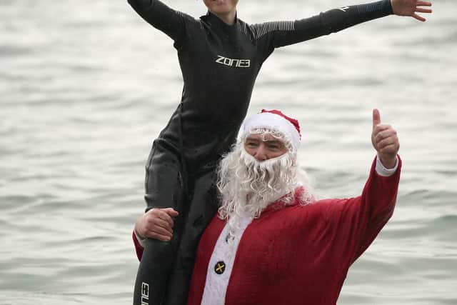 Veteran Christmas swimmer Patrick Corkery dressed in a full Santa tunic while his 12-year-old son Matthew dressed as an elf in a wetsuit.