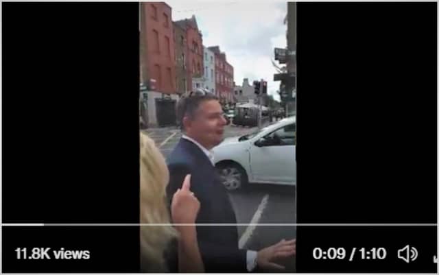 The video shows a small group of individuals shouting things like "mass genocide" and "God is watching"