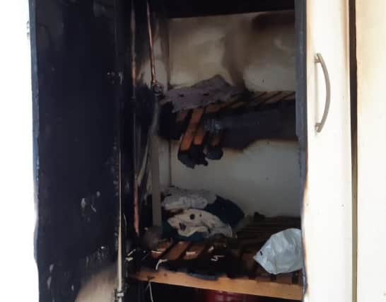 Photos of a fire in a hot press showed considerable damage including burned clothes, charred timber shelves and blackened walls.