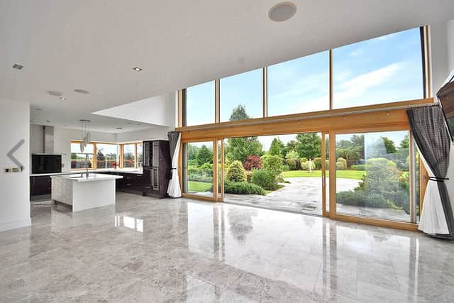 At ground-floor level, the accommodation comprises an open-plan living/dining and kitchen. The living/dining area features full-width sliding patio doors which open to the garden, and above which is a 6.5m high ceiling to the mezzanine level. There is also a raised, enclosed, dual aspect, solid fuel fireplace.