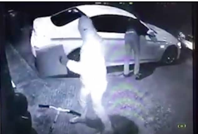 CCTV showing two men stealing a car using keyless fob tools