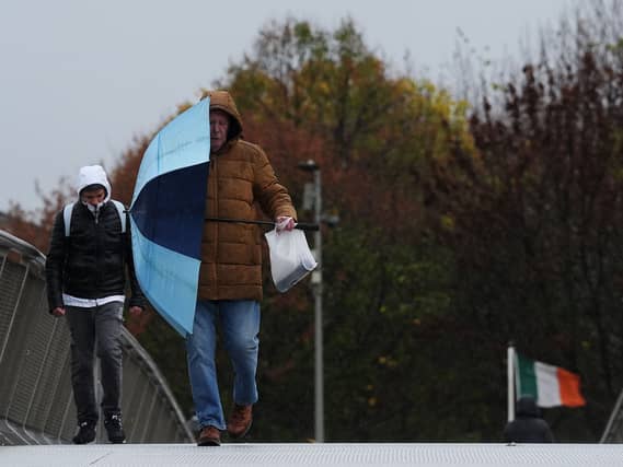 A man holds an umbrella in windy conditions