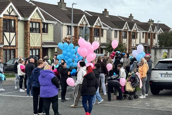 People gather ahead of a balloon release ceremony in Birchwood on Wednesday